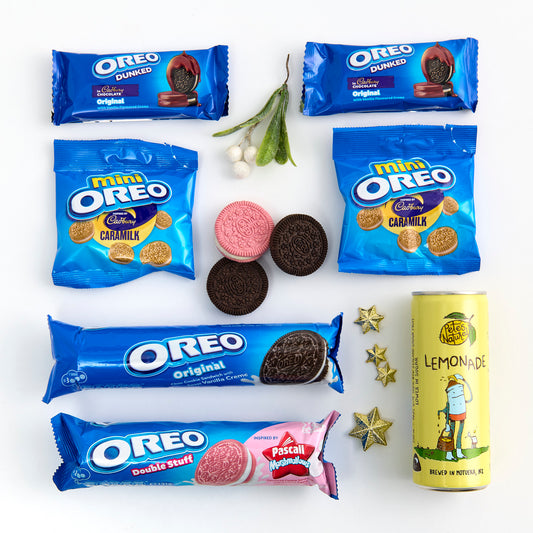 Various Oreo cookie packages and a can of lemonade on a white background