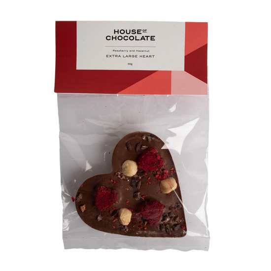 Heart-shaped chocolate bar with berries and nuts in a clear package with 'House of Chocolate' branding.